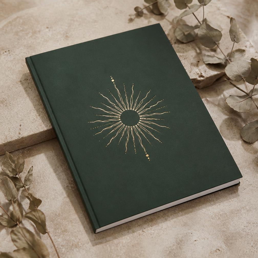 Deep green workbook with a gold sun emblem on cream stone