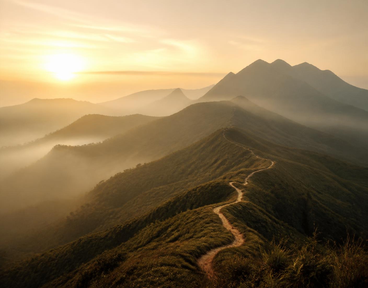 Green mountain ridges wrapped in golden morning mist